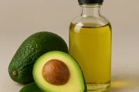 Green oil in glass bottle with avocado's to the side