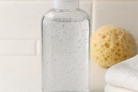 Bottle of clear shower gel in bathroom setting