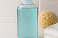 Shower gel in a bottle with sponge and towel