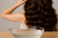 Shampoo base in a bowl in front of a lady with lovely hair