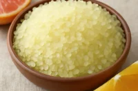 Bowl of Forget your troubles bath salt accompanied by citrus fruit